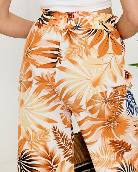 Royalfashion Biało-pomarańczowe damskie spodnie palazzo z roślinnym wzorem